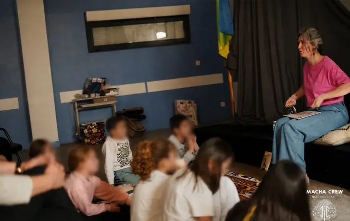 Une conteuse raconte une histoire à un groupe d'enfants aux visages floutés.